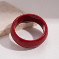 Detail of a chunky red resin bangle with a glossy finish on a textured background - Solid Glossy Red Bangle