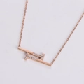 Detalle macro del collar geométrico de oro rosa con incrustación de circón blanco - Oro rosa