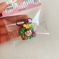 Close-up of a resin Christmas wreath keychain with a cute girl and brown bear - Flower Garland / Green