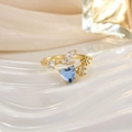 Macro shot of gold ring with heart-shaped blue gemstone and marquise zircon accents - Deep Blue Heart Floral Cluster (JZ0152C)
