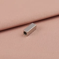 Cuenta rectangular de acero inoxidable pulido con agujero central sobre tela rosa - 2x4mm / Color Acero