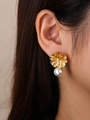 Elegant gold flower earrings with white pearl and sparkling crystals on model - Gold