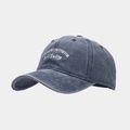 Detailed close-up of white embroidered text on vintage washed navy blue denim baseball cap - Adjustable / Navy Blue