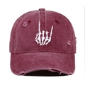 Close-up of skeleton hand embroidery and distressed detail on washed cotton baseball cap - Burgundy