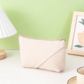 Beige dumpling makeup bag with pleated texture on a modern home decor background - Beige Yuanbao Bag