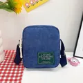 Minimalist blue corduroy square crossbody bag with adjustable strap and front label - Dark Blue