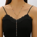 Detailed view of fashion gold Y-necklace with multi-color round gemstones on model - Gold Multicolor Round Diamond Y Necklace (9286)