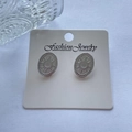 Vintage oval silver earrings with starburst engraving and dotted border on a display card - Star Burst Oval / Steel