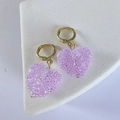 Close-up of sparkling purple crystal heart-shaped earrings with golden hoop closure - Purple
