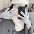 Close-up of grey knitted gloves with pink panda detail and white plush scarf - Panda Grey