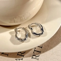 Orecchini a cerchio geometrici intrecciati in argento su un piatto di ceramica - Fibbia per orecchie / Argento