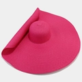 Detail of a large brim fuchsia straw sun hat showing high-density woven spiral texture - One Size / Rose Red