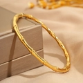Dettaglio di un bracciale in acciaio inossidabile dorato a forma di bambù su scatola - Oro