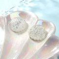 Macro-opname van witte glitterhars schelpen op een parelmoerachtig schelptray - Helder Wit