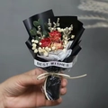 Nahaufnahme kleiner Strauß roter Trockenrosen mit Best Wishes Text in schwarzem Papier - Rote Rose (Schwarze Verpackung)