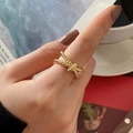 Französischer Vintage Goldring mit Knotendesign am Finger in eleganter Kulisse - Gold