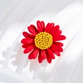 Detailed macro view of vibrant red daisy brooch with textured yellow floral center - Red Daisy