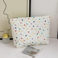 Detail of white quilted makeup bag with colorful polka dots and metal zipper closure - Colored Polka Dots