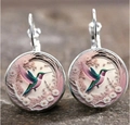 Vue macro détaillée de boucles d'oreilles argentées avec motif colibri coloré et fleur - Style 1