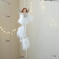 Ángel navideño de felpa con falda de malla blanca y alas brillantes en entorno festivo - Blanco