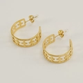 Boucles d'oreilles créoles dorées avec motif croix ajouré et finition métallique sur blanc - Doré