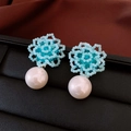 Detailed view of light blue beaded flower earrings with a large white imitation pearl drop - Silver Earring Post-Blue / Blue