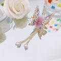 Golden butterfly hair clip with purple gems, pink pompom and pearl tassels in a mirror view - Mink Fur Tassel Butterfly / Purple