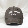 Detailed close-up of white BAD HAIR DAY embroidery on charcoal washed cotton baseball cap - Coffee