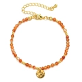 Detail of beaded bracelet with orange faceted stones, gold spacers, and hammered pendant - Orange