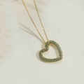 Collana con ciondolo a cuore dorato e cristalli verdi su sfondo crema materico - Oro/Zirconia Verde