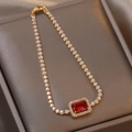 Dettaglio di un bracciale geometrico dorato con pietra rossa rettangolare e pavé di zirconi - Bracciale Rosso / Rosso