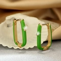 Detailed macro view of U-shaped gold hoop earrings with green enamel and zircon stones - Green