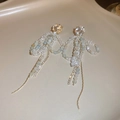 Vue détaillée des boucles d'oreilles longs pompons dorés avec perles de cristal - Doré