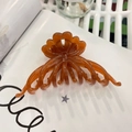 Detail of amber brown resin hair claw clip with wavy edges on white book pages - Approx 11cm / Translucent Dark Orange