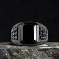 Macro detail of men's punk ring with emerald-cut black stone and paved black crystals - US 7