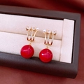Makroaufnahme von 18K vergoldeten Ohrringen mit roten Perlen und glitzernden Zirkonia - Schleife Perle Modell (Silbernadel)