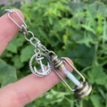 Detail of silver anchor and bronze hourglass charm with white sand on a metal keychain - Style 8 (Anchor + Hourglass)