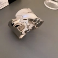Detailopname van een brede gepolijste zilveren metalen armband met scharniersluiting - Onregelmatige Rimpeling / Zilver