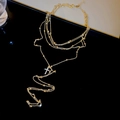 Vue macro du collier doré multicouche avec pendentif croix serti de zircons - Style Croix / Doré