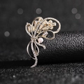 Detailed view of elegant gold brooch with sparkling rectangular zircons and a white pearl - Bouquet Zircon Brooch