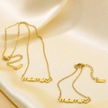 Macro detail of gold-plated mami letter necklace with heart pendant on silk background - Gold Set (KS217154-KLX)