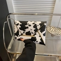 Dettaglio borsa a busta con stampa animalier e bordi decorativi in metallo dorato - Stampa mucca