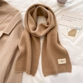 Flat lay di una sciarpa in maglia color cammello con etichetta emo accanto al caffè - Cammello
