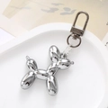 Detailed close-up of a silver metallic balloon dog keychain on a white tray - Gun Black