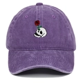 Close-up of a skull and rose embroidery on a washed purple cotton baseball cap - Purple
