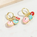 Detailed shot of golden evil eye hoop earrings with pink, blue and red enamel charms - Evil Eye Style (ES2648)