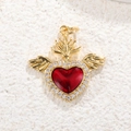 Macro shot of gold-plated red heart pendant with crystal wings on white stone - R008-Wings Flame Heart