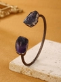 Detailopname van een vintage bronzen manchetarmband met onregelmatige amethiststenen - Amethist