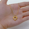 Elegant gold hollow heart pendant necklace with fine snake chain displayed in hand - Small Heart
