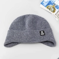 Dettaglio del berretto in maglia grigia con trama a coste e toppa con logo a stella - Grigio chiaro